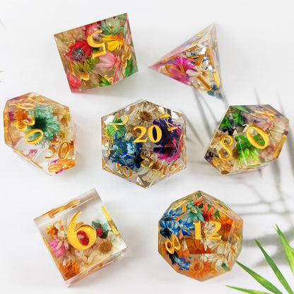 Set of colorful resin dice with embedded flowers on a white background